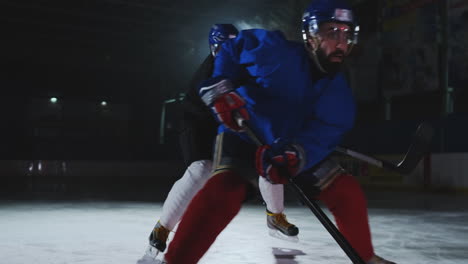 Two-man-playing-hockey-on-ice-rink.-hockey-Two-hockey-players-fighting-for-puck.-STEADICAM-SHOT